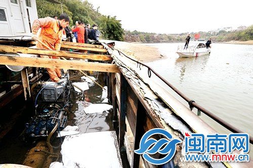 泄漏机油的是一艘小木船,工作人员在船内放入吸油毡