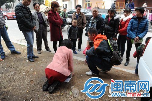 女子在路邊長跪不起，記者和路人勸其起來，但無果