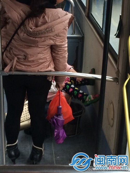 一位母親用公交車上的垃圾桶為女兒把屎