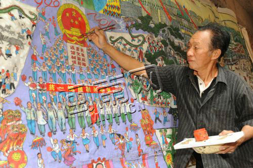 翔安区农民画画家梁金城在作画