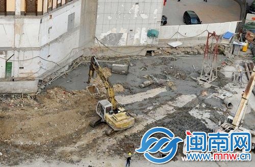地铁围挡工地，堆满黄泥黄沙，工人在一旁施工，却没有防尘措施