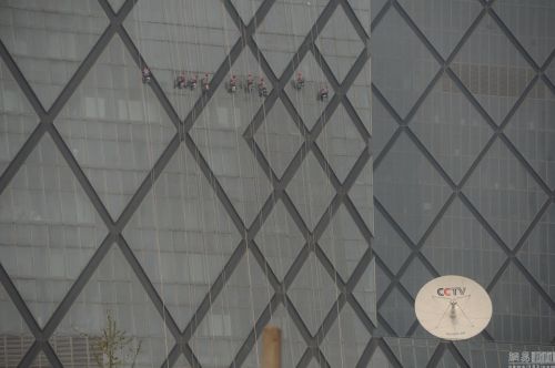 记者再次来到央视大楼东面想一睹清洗央视大楼的盛况，看到楼顶确实有四五个工作人员在摆弄楼顶的绳索