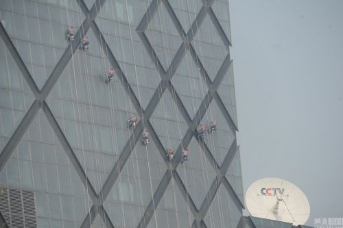 2015年4月9日消息，北京，近日有央视记者发微信说，央视新址大楼正在开始建成以来的首次外里面清洗，清洗费用50万元人民币，耗时需要40天。图为在央视大楼的外吊着绳索的工作人员。