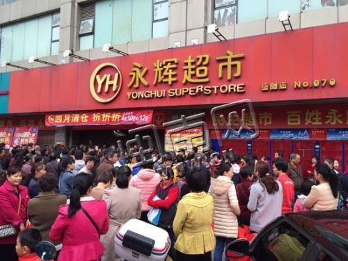 超市门前聚集着待购物的居民