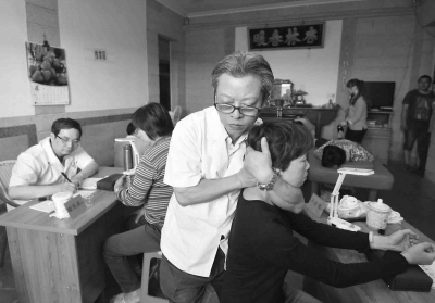 卓播儒正帮村民推拿按摩。