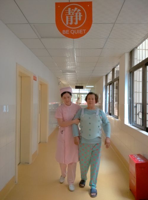 护士搀扶着患者在走廊上走动