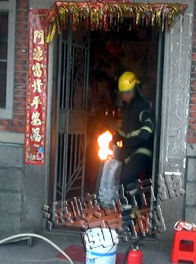 消防员搬出正在燃烧的液化气瓶