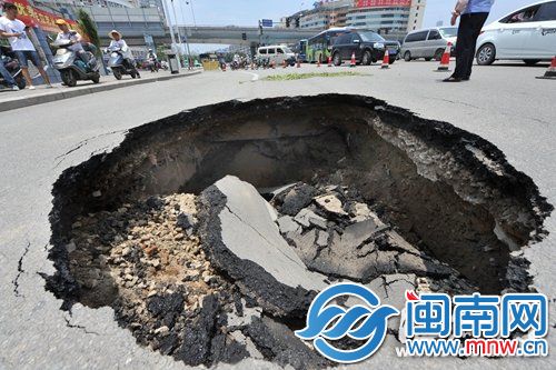 路面突现大坑，不少车辆停下拍照，现场交通受影响