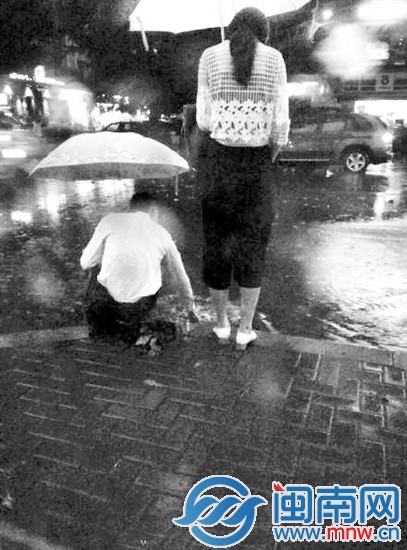 男子蹲在路边掏下水口（网友“银河仲夏之夜”供图）
