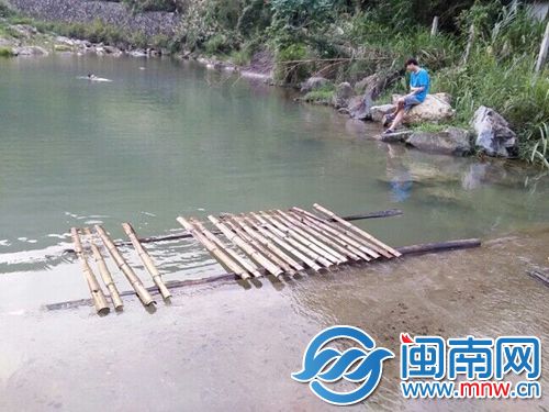 水塘里还有人游泳，一旁就是小黄同伴说的木筏