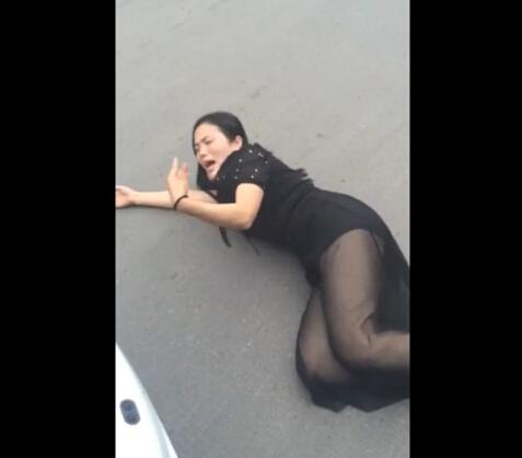 女子臥倒在車前