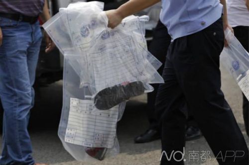 今天（6月29日）下午兩點(diǎn)十分左右，在廣州大學(xué)城自行車館，殯儀館人員把尸體清出現(xiàn)場(chǎng)，警方在現(xiàn)場(chǎng)帶出證物，其中包括一塊廁所門板和一雙紅色的運(yùn)動(dòng)鞋。南都記者 張志韜 攝