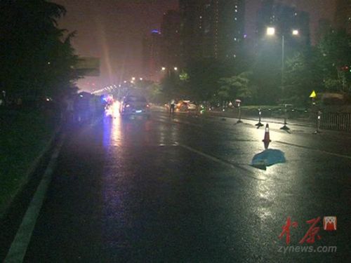 事故現(xiàn)場(藍(lán)布覆蓋的為被撞女子，前方為肇事車輛)