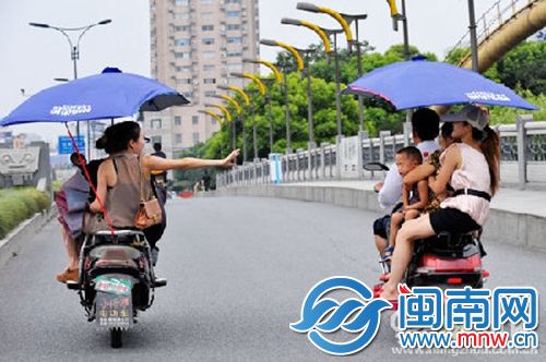 违规加装遮阳伞的电动车，易翻车还危及行人安全（资料图）
