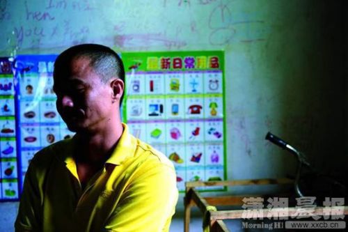 圖為7月1日，江鋒坐在客廳里，身后是6歲兒子小嘉認字的掛圖，他說不怪妻子李玲，&ldquo;她這么做是壓力太大了。&rdquo;圖瀟湘晨報記者陳勇