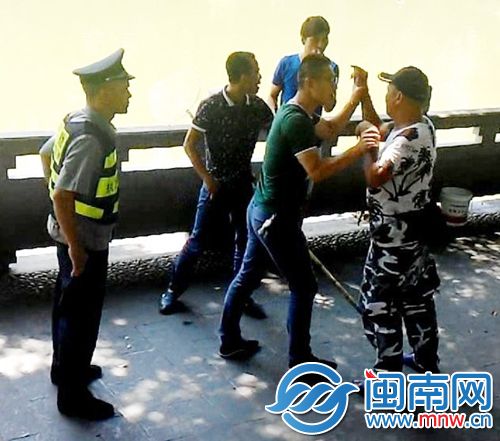 捞鱼者（右一）与劝阻捞鱼的市民（左二）发生肢体冲突，有市民和协勤上前劝架