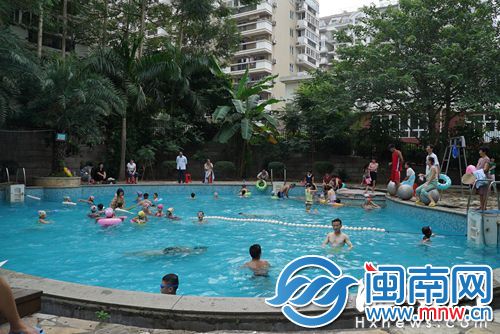 塞纳阳光小区里，站在泳池边的游泳教练同时也是救生员