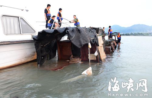 执法人员对浮出水面的采砂船进行抽水