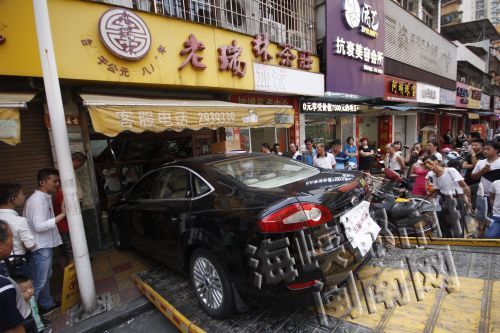 小车一头栽进路旁茶叶店,引来市民围观