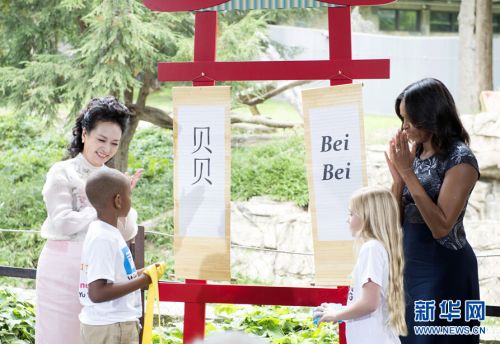 9月25日，国家主席习近平夫人彭丽媛同美国总统奥巴马夫人米歇尔在华盛顿共同参观美国国家动物园大熊猫馆。这是彭丽媛与米歇尔共同为大熊猫幼崽选定名字“贝贝”。新华社记者王晔摄