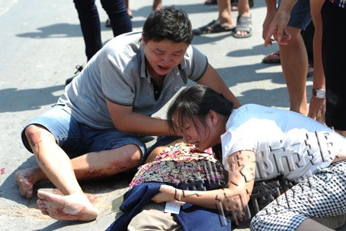 女子把新衣服披在母亲身上，泣不成声