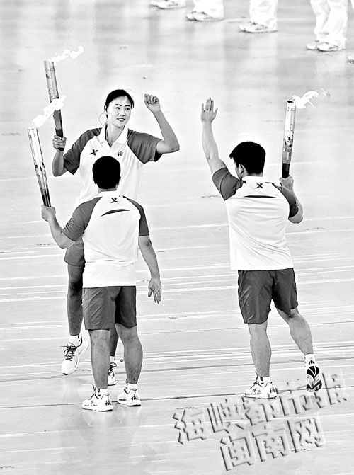 张湘祥和林清峰将圣火传给主火炬手薛晨