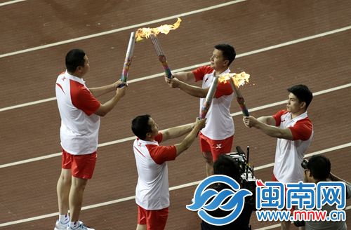 第二棒的石智勇和吉新鹏，向第三棒的张湘祥和林清峰传递火炬