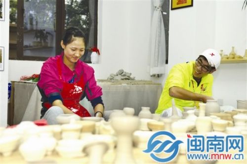 合肥队的运动员金明月（左）和志愿者一起制作陶艺