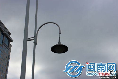 这盏路灯和灯罩，全靠一根电线挂着，风一吹摇来晃去
