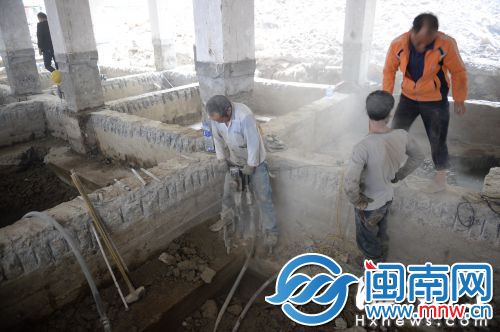 工人用钻孔机打孔，现场尘土飞扬