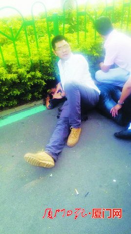 ▲这名穿白衬衫、戴眼镜的小伙帮忙将嫌疑男子控制住。