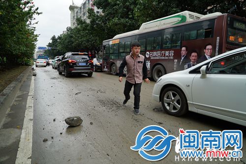 这辆小车被这块石头刮伤了底盘，司机顶起车才将石头取出