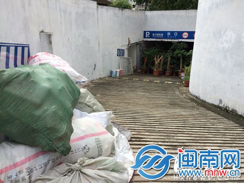 车库出口被铁丝网封住，外面摆满盆栽