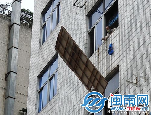 工人戴着防尘面具，将垃圾从楼上直接扔下