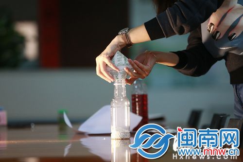 记者将30克干燥剂倒入塑料瓶中