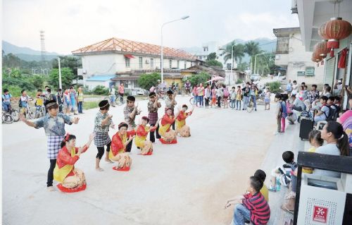 在五一新村队部大门口,阳光舞蹈队在排练新舞,吸引了一群周边群众围观。