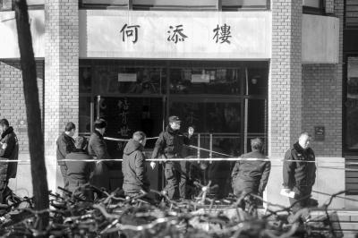 2.警方封锁何添楼，现场拉起了警戒线，勘查人员走出楼外。