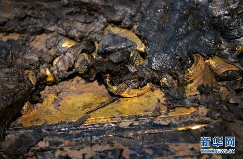 12月22日，江西海昏侯墓考古人员在主棺的内外棺之间发现了多块金板。经秦汉考古权威专家确认，这是汉墓考古史上首次发现的金板，或将提供墓主人的重要信息。金板位于内棺和外棺之间的南侧空隙处，在精美的漆箱下面。目前，金板只露出一角，具体大小还看不清，目测有好几块叠压在一起。记者 程迪 万象 图片来源：新华网