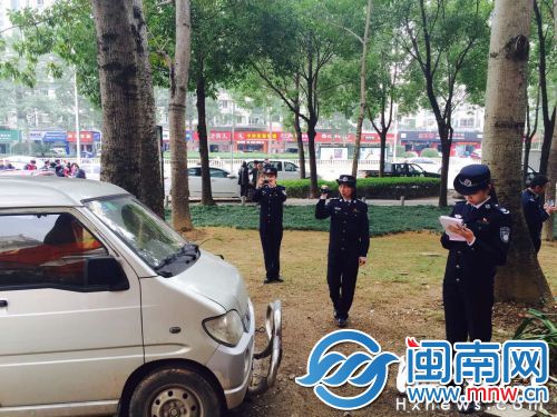 金山大道，女队员们对停放在绿化带上的车辆进行取证处罚