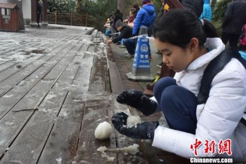 一名小姑娘在把玩积雪。