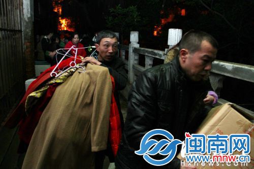 天气寒冷，居民抱着还未晾干的衣物紧急撤离火场