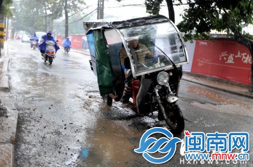 延平路坑洼遍布，一辆经过的三轮摩托差点侧翻