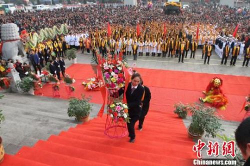 图为参拜人员向医圣敬献山茱萸、山药、丹皮、地黄等六味优质中药材。