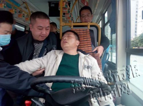 陈师傅晕倒在驾驶座上，被众人扶下（公交公司供图）