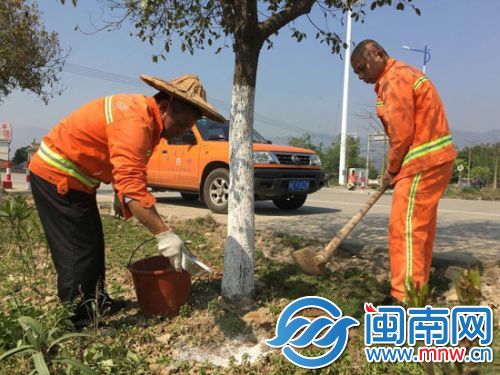 养护工人正对专养的各条公路绿化进行施肥 商燕青摄