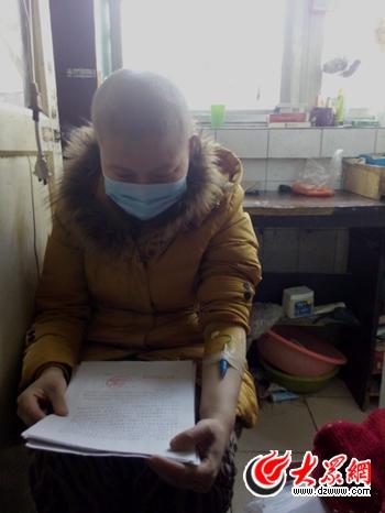 已经没钱化疗的丁珍，看着法院判决书潸然泪下。丈夫没法和她离婚，却带着儿子&ldquo;消失&rdquo;了。（记者 王宗阳 摄）