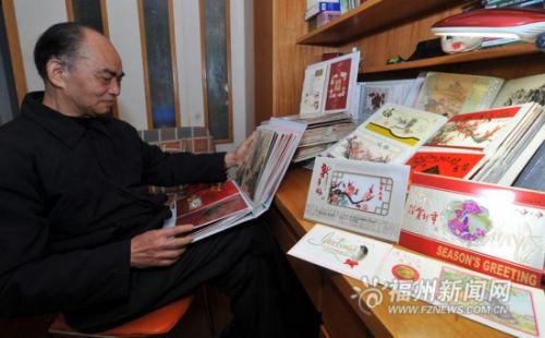 陆老先生向记者展示收藏的贺卡。