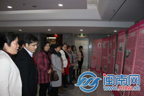 图为妇女群众观看反家庭暴力法宣传展板