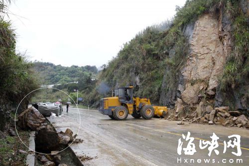 巨石滚落，面包车被砸中，侧翻在路上（图中画圈处）