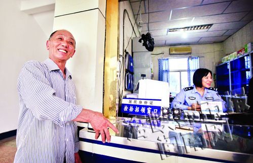 老郑高兴地按照民警提示核对指纹，准备领取身份证